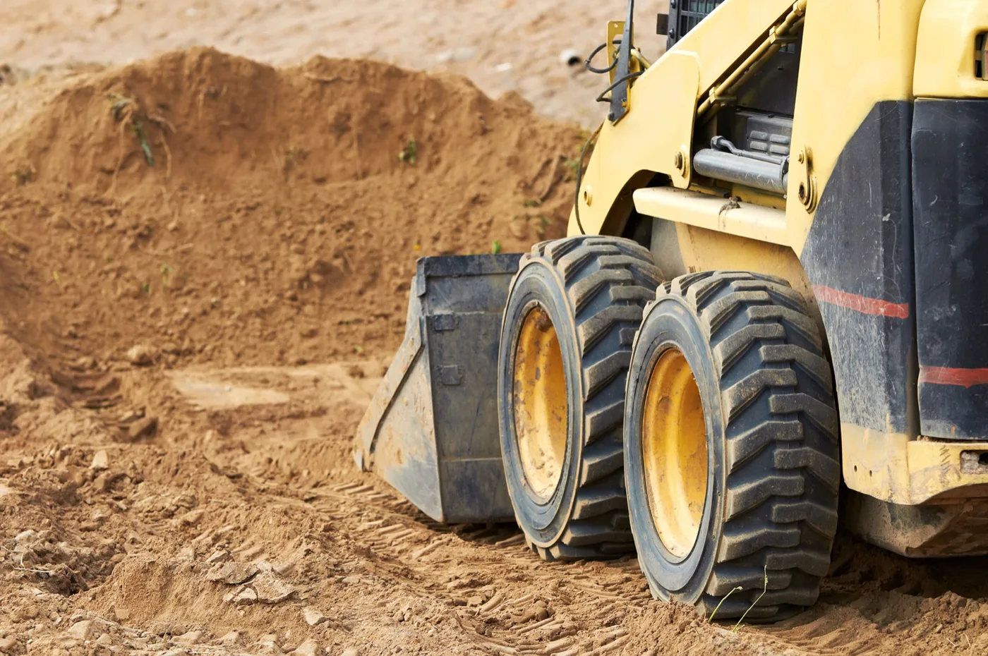 Skid steer loading gravel from a dump trailer on a Snake River Valley property